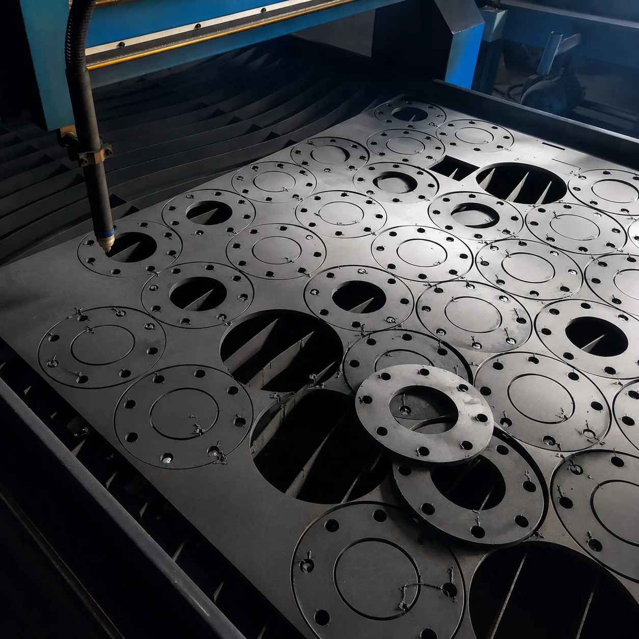 Sheet metal nesting software: flanges nested on a steel plate on a plasma cutting table